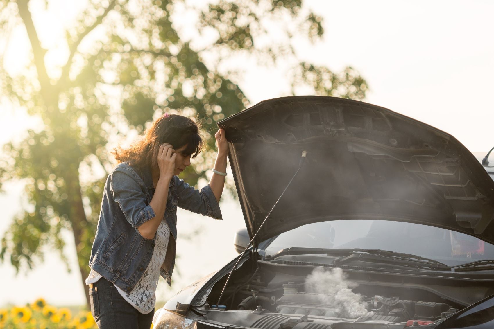 Woman Standing Next to Car That's Overheated